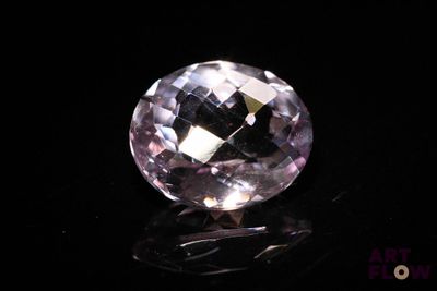 a close up of a pink diamond on a black surface