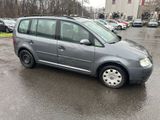 the small gray van is parked in the parking lot on a rainy day