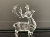 figurine de renne en verre transparent posée sur une surface noire
