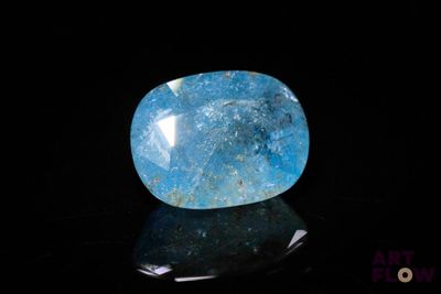 a close up of a blue stone on a black surface
