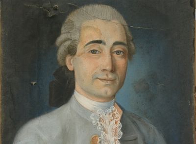 portrait d'un homme en costume bleu, portant une cravate en dentelle blanche