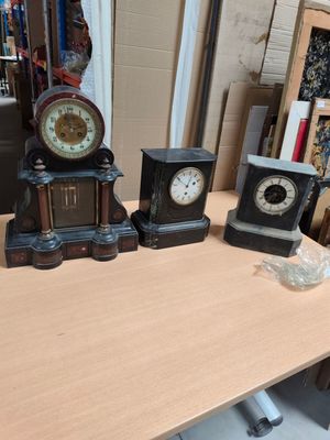three clocks sitting on a table next to each other