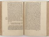 an open book on a white surface with a black border