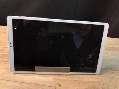 une tablette cassée posée sur une table en bois