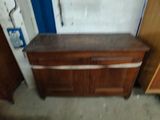a wooden dresser with a metal handle in a room