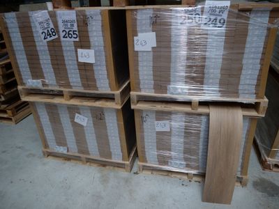 Plusieurs caisses en bois sont empilées sur des palettes dans un entrepôt