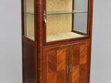 a wooden display cabinet with marble top and glass doors