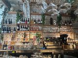 many wine glasses hanging from the ceiling above the bar