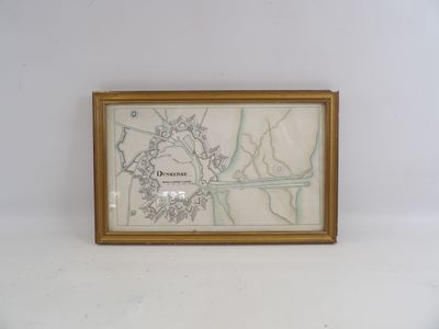 une vieille carte d'une ville, encadrée d'or, accrochée à un mur blanc