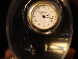 a glass ball with a clock inside of it on a table