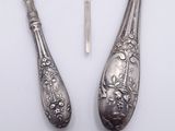 two spoons and a fork on a white surface