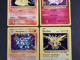 quatre cartes Pokémon aux motifs différents posées sur une table