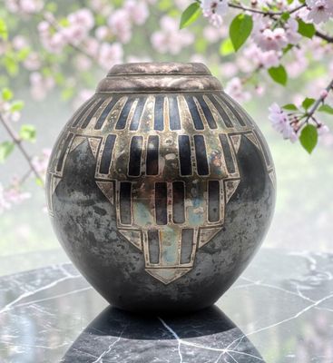 a vase that is sitting on a table with flowers in the background
