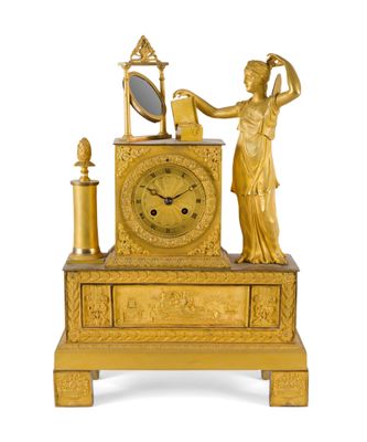 une horloge en or surmontée d'une statue