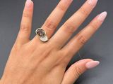 someone is holding their hand up with a ring on it ' s finger