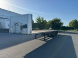 a flat bed trailer parked in front of a building