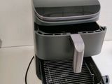 a gray and black coffee maker sitting on top of a white counter