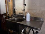 a stainless steel sink and a metal faucet in a room
