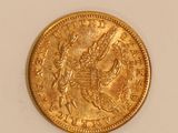 a close up of a gold coin on a white surface