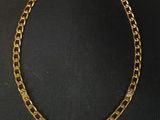 un collier à chaîne en or avec un fermoir en diamant sur fond noir