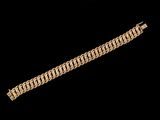 gros plan d'un bracelet en or sur fond noir