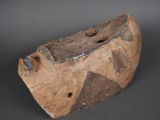 un objet en forme de vieux bateau en bois posé sur une surface grise