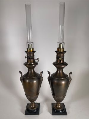 paire de lampes anciennes en forme d'urne en laiton, posées sur des socles en marbre