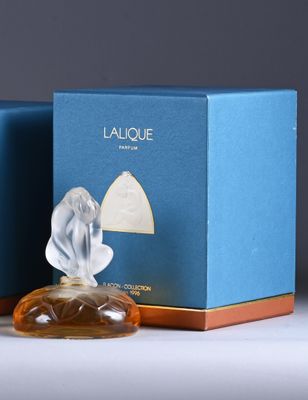 two bottles of perfume sitting next to each other on a table