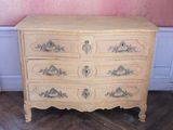 une commode en bois à tiroirs dans une pièce aux murs roses