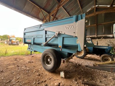 une photo d'un camion-benne bleu garé dans une grange