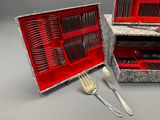 un coffret rouge contenant de l'argenterie, ainsi qu'une fourchette et un couteau