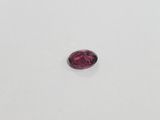 a pink tourmaline stone on a white surface