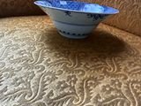 a blue and white bowl sitting on top of a couch