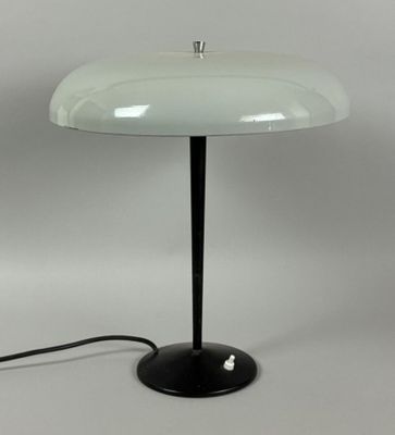 a black and white table lamp with a glass shade on it