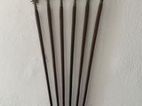 four metal swords are mounted on a white wall with a white background