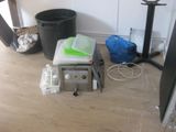 a microwave sitting on the floor next to a trash can and a trash can