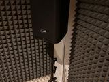 a speaker that is sitting on a tripod in a room