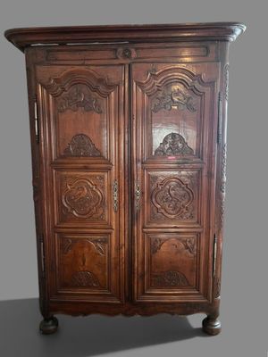 une photo d'une armoire en bois dont les portes sont ornées de sculptures