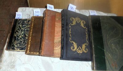 several old books are lined up on a table with tags on them