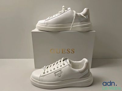 baskets en cuir blanc avec un logo doré sur le côté