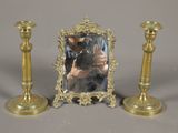 a picture of a mirror and two candlesticks on a table