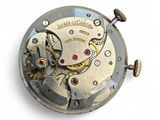 a close up of a pocket watch on a white surface