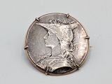 an image of a silver coin with a woman ' s face on it