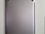 a silver tablet computer sitting on top of a white wall