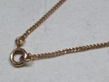 a gold chain with a heart on it on a table