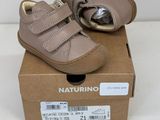les chaussures de bébé se trouvent dans une boîte posée sur une surface blanche
