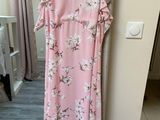 a pink dress hanging on a hanger in a room