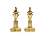 pair of antique brass candlesticks on pedestals on a white background