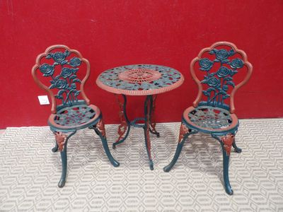 two chairs and a table on the floor in front of a red wall