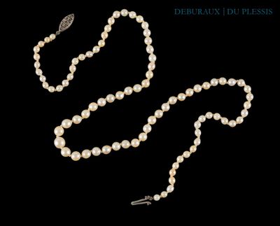 un collier de perles blanches muni d'un fermoir en argent, sur fond noir